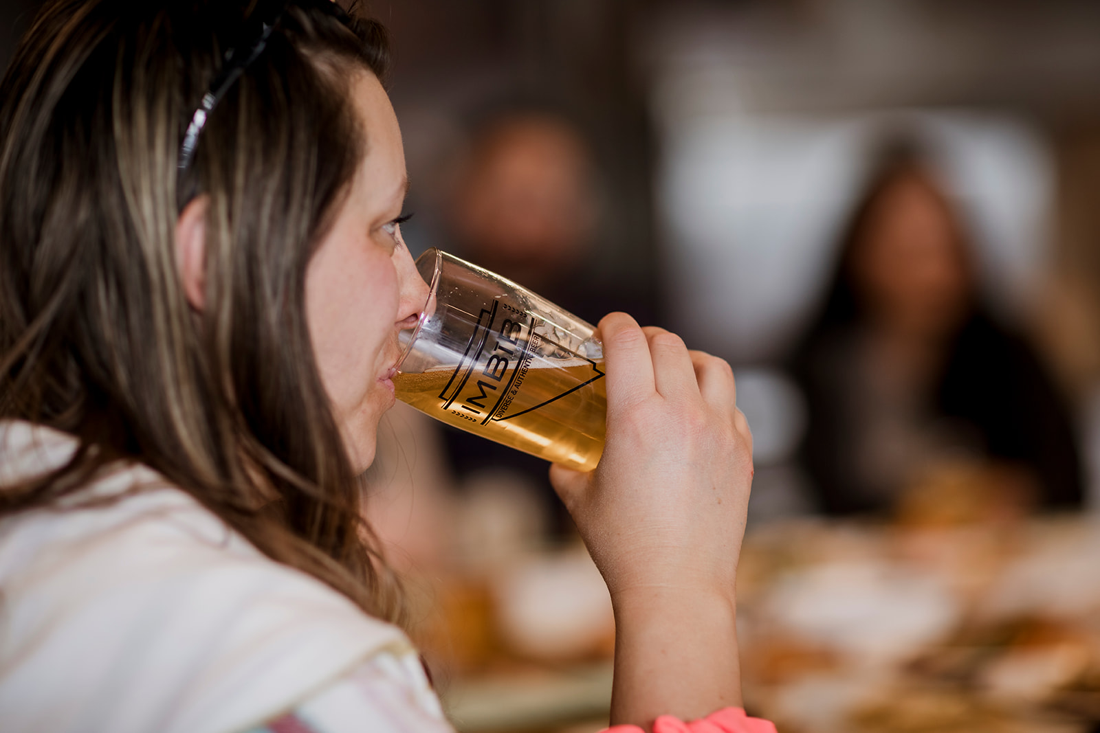 Girl enjoying imbib beer with friends